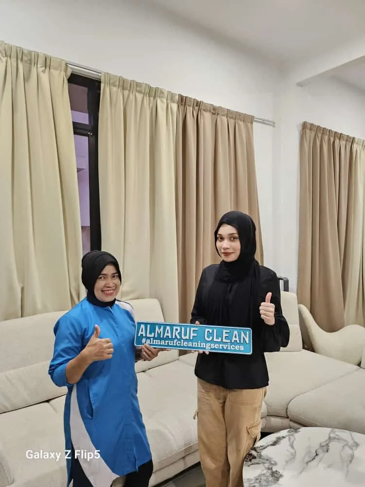 Almaruf Clean cleaner holding the Almaruf Clean sign with a customer after the job