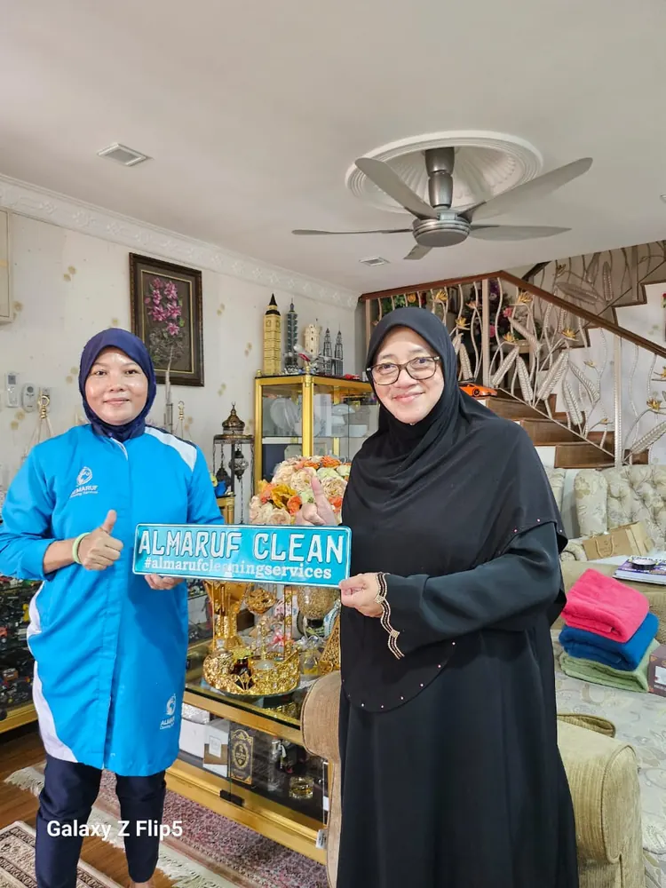 Almaruf Clean cleaner holding the Almaruf Clean sign with a customer after the job